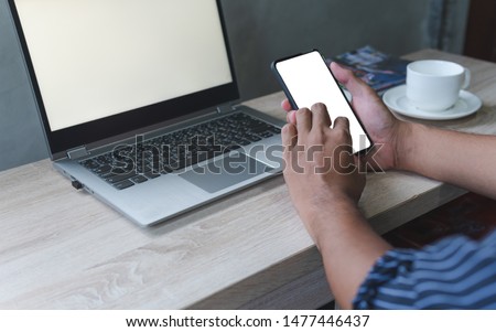 Business man hand holding smart mobile phone, using credit card for online shopping with laptop computer and digital tablet on table. Cyber concept
