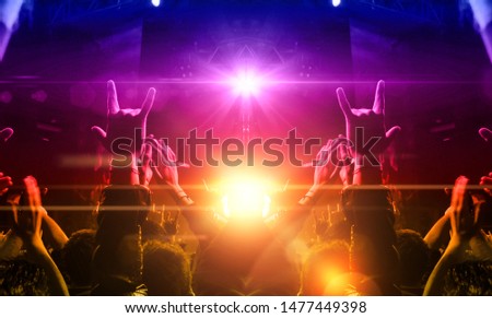 Concert spectators in front of a bright stage with live music