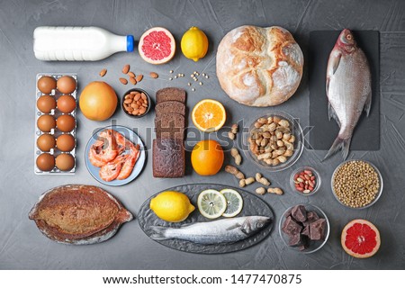 Flat lay composition with different products on dark grey background. Food allergy concept Royalty-Free Stock Photo #1477470875