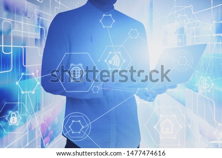 Young man in white shirt using laptop with double exposure of internet streaming and social media interface and hi tech icons. Concept of coding. Toned image blurred