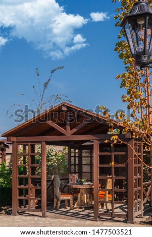 
Garden arbor made of wood, natural wood, shadow protection from sunlight, garden furniture, fruits on the table.