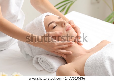 Young woman having facial massage in beauty salon Royalty-Free Stock Photo #1477510436