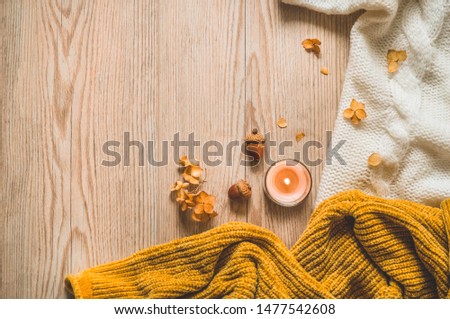 Background with warm sweaters and cup tea. Cozy still life in warm shades, space for text, Autumn winter concept. Copy Space.