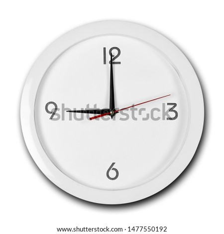 Large round white wall clock with white frame. The hands point to 9 o'clock. Close up. Isolated on white background.