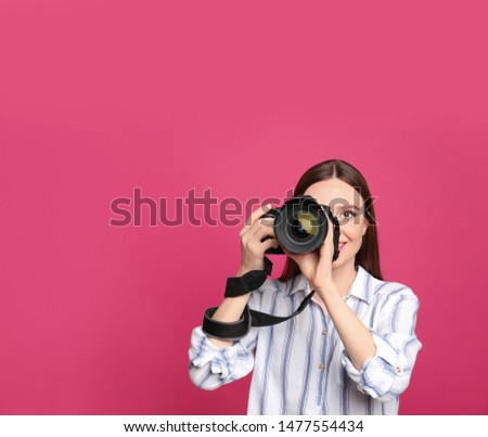 Professional photographer taking picture on pink background. Space for text
