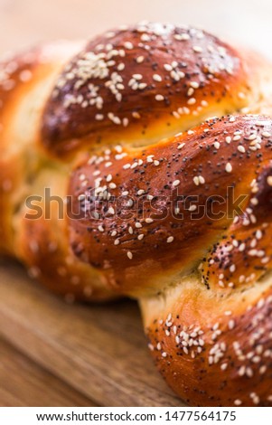 Close up of braided challah bread with sesame and poppy seeds.