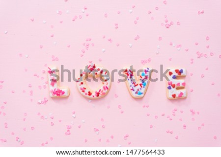 Flat lay. Sugar cookies decorated with royal icing on a pink background.