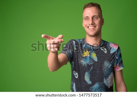 Portrait of happy handsome man laughing and pointing finger