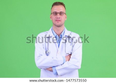 Portrait of handsome man doctor with arms crossed