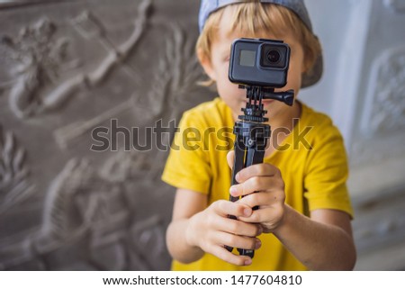 Little boy shoots a video on an action camera