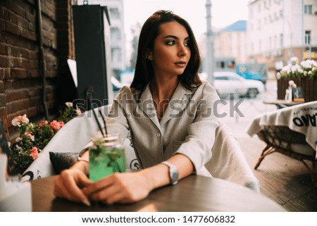 Girl in a suit drinks lemonade