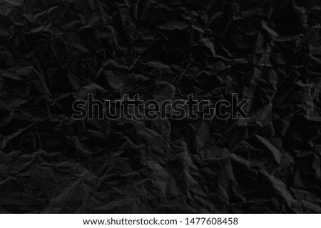 Old crumpled texture black cardboard sheet of empty paper black background.