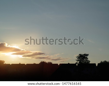 Sunset time, Urban area, House's roofs silhouettes against blue sky. Concept urbanization,