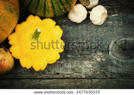 Patty pan, pumpkins and spices on old wooden table. Fresh seasonal vegetables