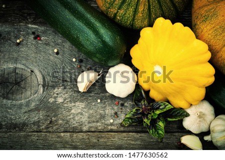 Patty pan, zuchinni, pumpkins and spices on old wooden table. Fresh seasonal autumn vegetables concept. 