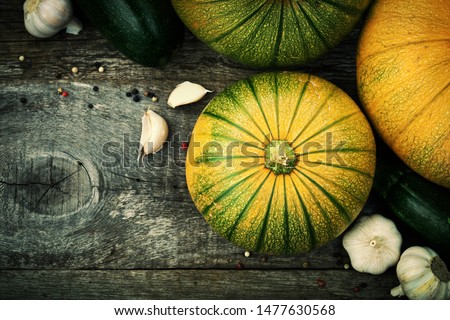 Patty pan, zuchinni, pumpkins and spices on old wooden table. Fresh seasonal autumn vegetables concept.