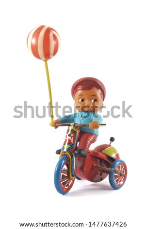 Zinc toys on a black and white background. Children riding a tricycle.