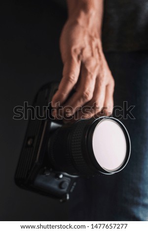 closeup of a young caucasian man with a reflex camera in his hand
