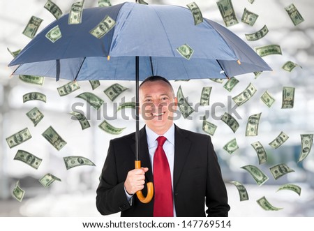 Happy man holding an umbrella in a money rain