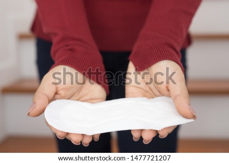 Close-up photos Red long-sleeved shirt women holding sanitary napkins.