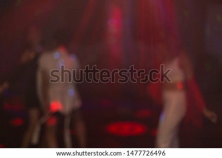 girls dance in night club on stage a few blurred silhouettes