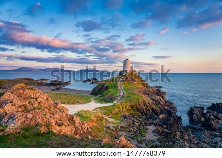 Ty Mawr Lighthouse at sunset on Llanddwyn Island in North Wales Royalty-Free Stock Photo #1477768379