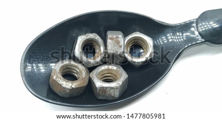 A picture of stainless steel bolts on black spoon