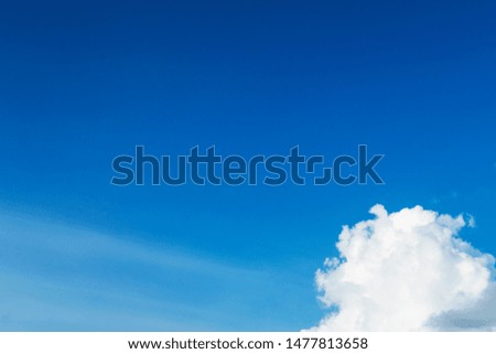 Copy free space for text on deep blue sky background with white puffy & fluffy cumulus or cumulonimbus cloud in tropical summer climate weather on sunny & sunshine day                                 