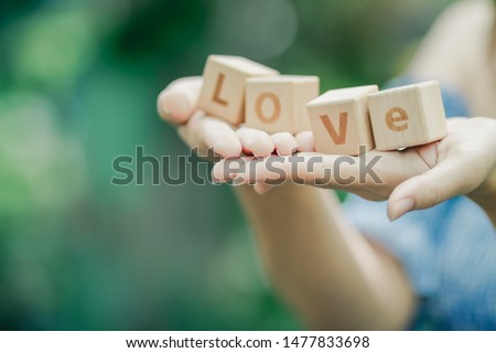 The girl holds a wooden cube with letters arranged on the hand as love words to convey meaning to her lover. Understand the message of her love on Valentine's Day.
Concepts, friendship and love
