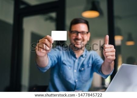 Mock up clipping path background backdrop white size of standard credit card smiling man holding empty credit card showing thumb up for quality of service an customer satisfaction