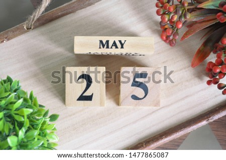 May 25. Date of May month. Number Cube with a flower and Sign wood on Diamond wood table for the background.