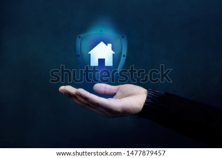 House or Family Insurance Concept. Company Supporting and Protecting their Customer by Shield, Home Icon floating over a Careful Gesture Hand of a Businessman Royalty-Free Stock Photo #1477879457