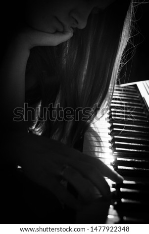 Black and white image of female playing the piano