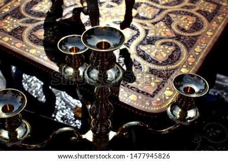 Mystic oriental background with metallic chandeliers and wooden carved inlayed table on the indian market, oriental luxury, atmospheric photo