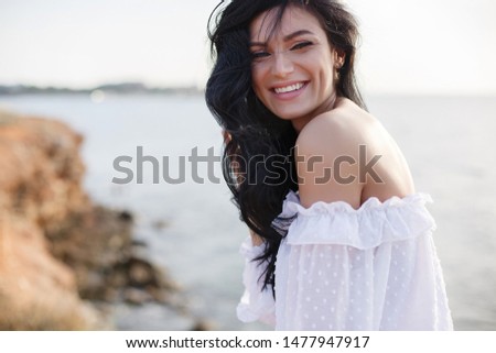 woman walking by sea. summer light sunny portrait. smiling girl with long hair and beautiful smile. summer girl portrait