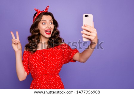 Beautiful lady with telephone in hands making selfies show v-sign wear off-shoulders dress isolated purple background