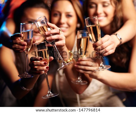 Group of partying girls clinking flutes with sparkling wine Royalty-Free Stock Photo #147796814