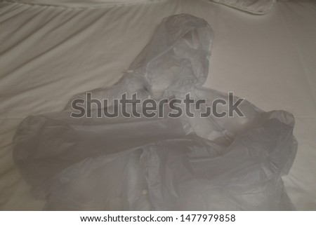 a white oilcloth raincoat lies on a white background 