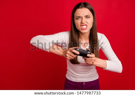 Photo of furious woman out of control losing video game while isolated with red background