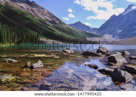 consolation lakes in Banff national Park, Canada. clear water on the Alpine lake, rocks on the foreground, Rocky mountains in the background, pine forest
