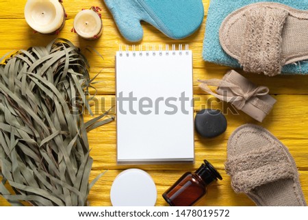 Spa blank page notepad with a copy space mockup. Bath accessories on a yellow wooden floor background.