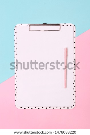Clipboard with pen at creative pink and blue background. Workspace mockup. Flat lay, top view