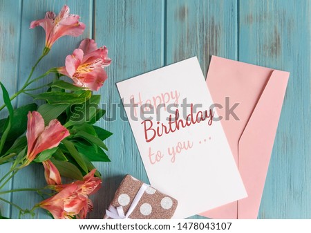 Happy Birthday to You. Birthday greeting card with flowers on a wooden background. Greeting card for girls, congratulations on mother's day. View from above