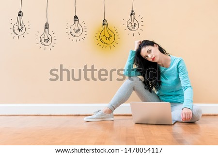 Idea light bulbs with young woman using a laptop computer