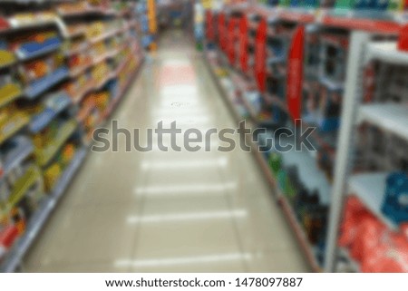 Abstract blurred grocery store aisle with colourful products on display shelves as background. Supermarket with bokeh.