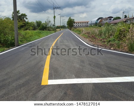 The yellow line divides the lane on the road. The cement road has a yellow lane dividing line to reduce accidents. The structure of the road made of cement.