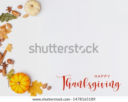 Thanksgiving Greetings. Pumpkins and dry leaves on a white background. Top view.