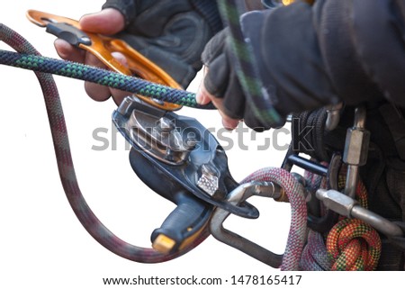 Top view picture of industrial rope access worker hand connecting Nylon low stretch 
rope into descender which its attached with harness loop working at height abseiling isolated white background