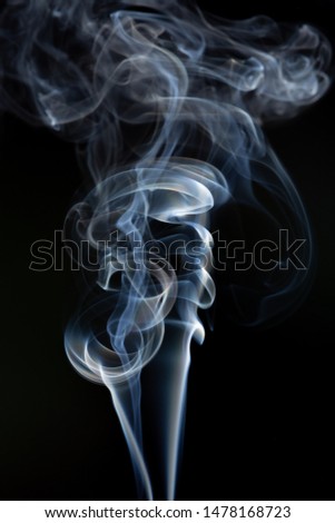 Abstract image of twisting incense smoke on a black background.