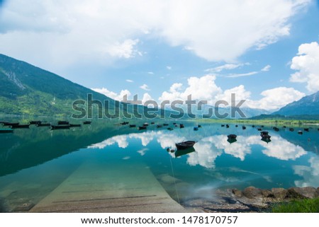 a beatiful view of Santa Croce lake. Wooden boats